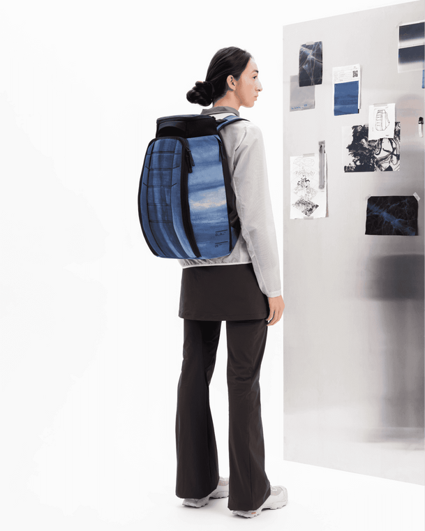 Db Hugger Backpack 25L in Ultraviolet worn by a model standing in front of a design board.
