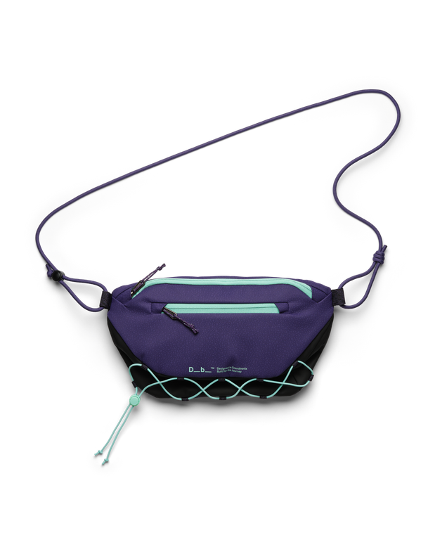 Db Roamer Pro 6L sling bag in black and purple with teal zippers and elastic bungee cord.